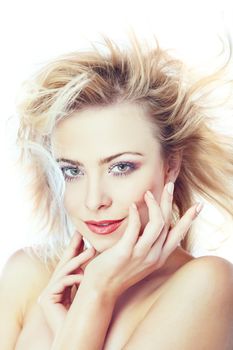 Young beautiful lady with blown hairs on a white background. Vertical photo with natural colors