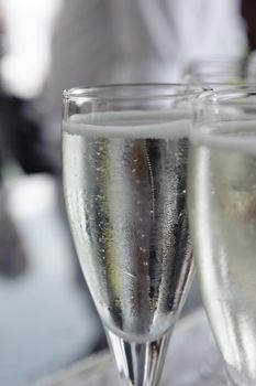 Pouring sparkling beverage on flute glasses