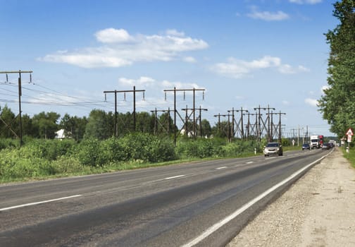 Wooden supports the electrical line along the highway. Russia