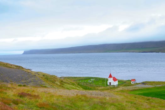 Small white church near the ocean, Iceland. Summer day.