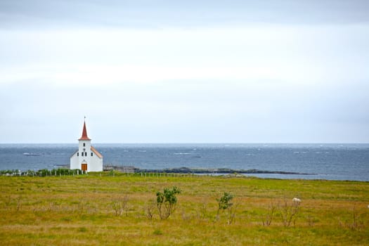 Small white church near the ocean, Iceland. Summer day.