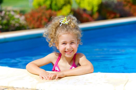 Pretty little girl in swimming pool outdoors
