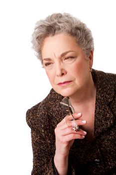 Beautiful senior woman with gray hair thinking about future holding glasses, isolated.