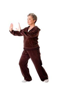 Beautiful Senior woman doing Tai Chi exercise to keep her joints flexible, isolated.