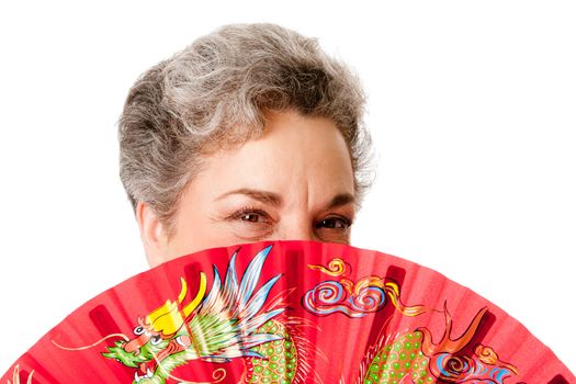 Beautiful Senior woman with gray hair and red Chinese dragon fan, isolated.