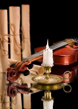 old violin witn candle ond old scroll of paper
