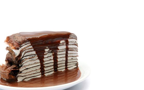 Close up crape cake with chocolate sauce isolated on white with space for text