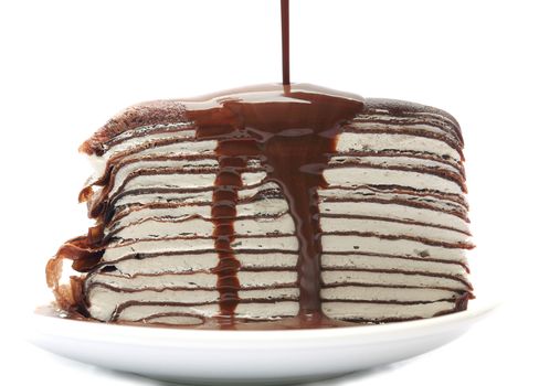 Close up crape cake with chocolate sauce pouring isolated on white background