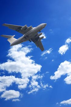 Big modern jet plane flying in blue sky with clouds