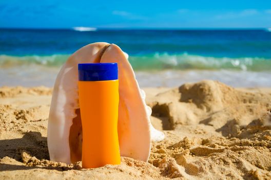 Seashell and sunscreen on sandy beach in Hawaii, Kauai