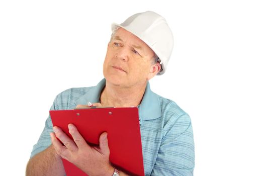 Serious middle aged construction foreman with hard hat writing on clipboard.