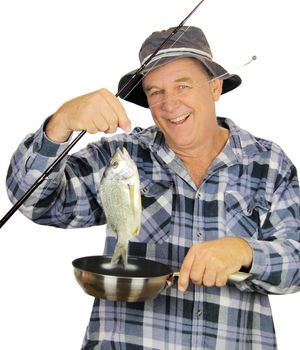 Middle aged fisherman drops freshly caught fish into fry pan.