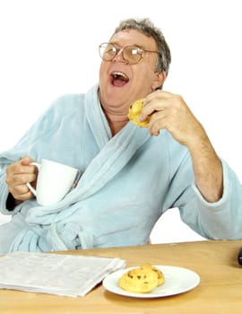 Nerdy middle aged man guffawing loudly at the breakfast table with a cup of tea.