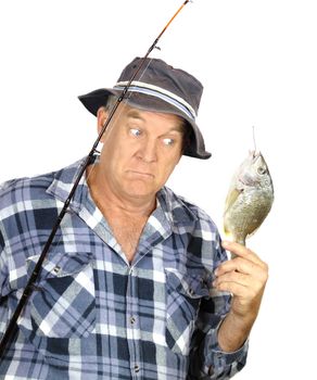 Middle aged fisherman is surprised by the size of his catch.