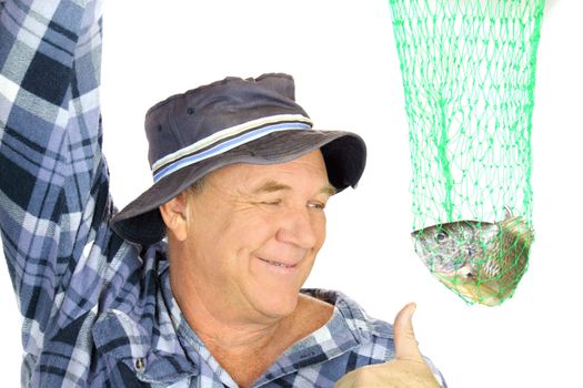 Proud fisherman holds his catch up in a net with a thumbs up.