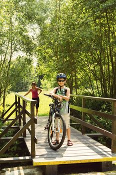 teenager relaxing on a bike trip on wooden bridge in sunny day