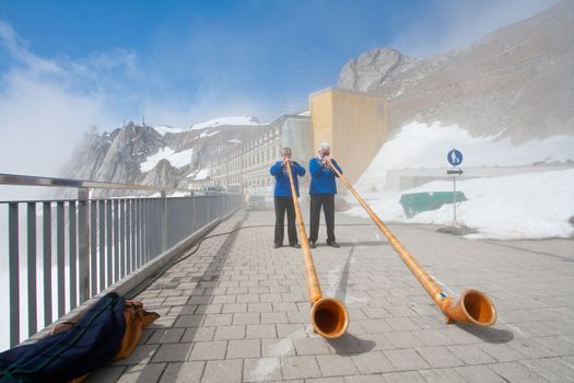LUCERN, SWITZERLAND - APRIL 10 : Unidentified musicians are playing music with Alpine horns at Pilatus Mountain in Lucern Switzerland on April 10, 2010.