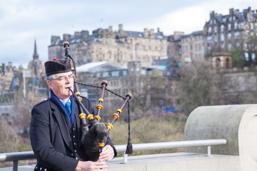 EDINBURGH, SCOTLAND, UNITED KIINGDOM - APRIL 10 : Unidentified Scottish Bagpiper playing music with bagpipe at Edinburgh on April 10, 2012.
