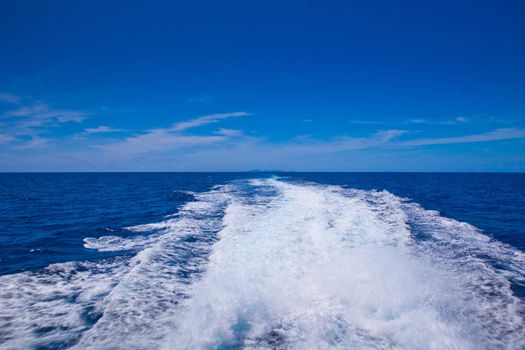 speedy boat prop wash, white wake on the blue ocean sea