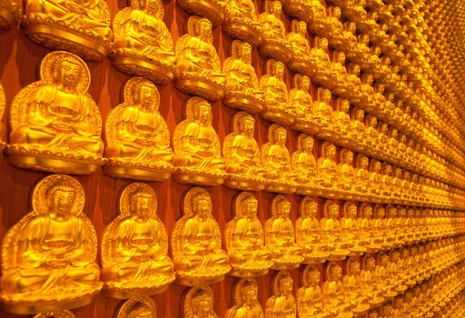 golden Image buddhas lined up along the wall of buddhist temple