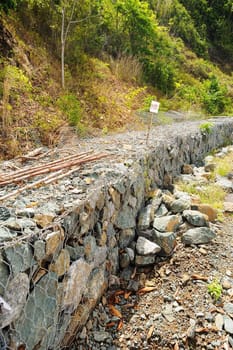 Rock blocks prevent landslides in contry road.