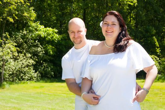 Happy young couple dressed white in the nature