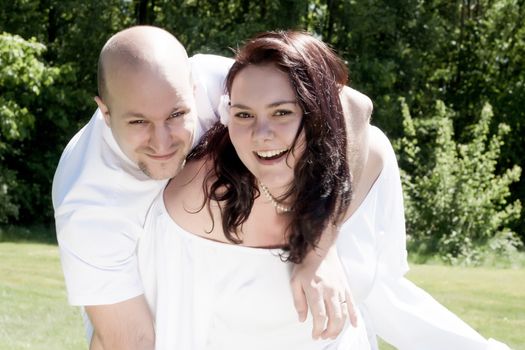 Happy young couple dressed white in the nature