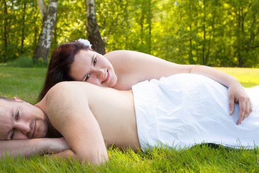 Happy young couple dressed white in the nature