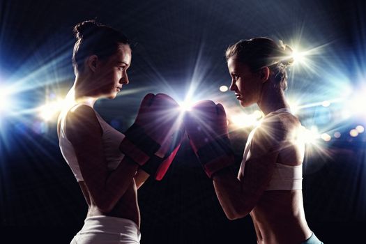 Two boxer women in gloves greet each other before fight