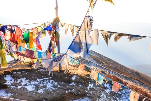 Praying flags floating in the wind in front of the Kangchenjunga is the third highest mountain