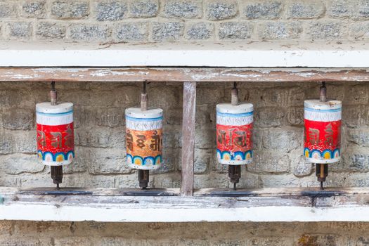 Buddhist prayer wheels in Tibetan monastery with written mantra, Yoksom, Sikkim, India.