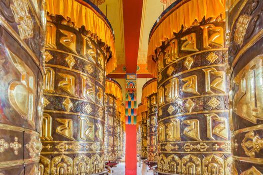 Buddhist prayer wheels in Tibetan monastery with written mantra, Yoksom, Sikkim, India.