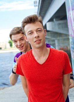 Portrait of happy teens boy with his friend looking at camera. Vertical view