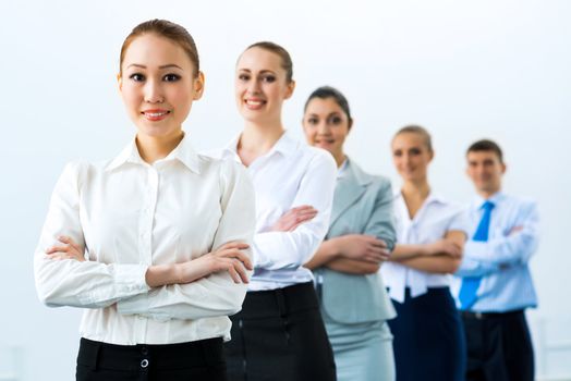 group of business people standing in a row, smiling and crossing his arms