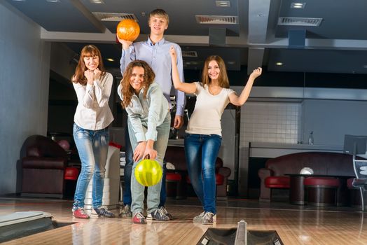 Group of young friends playing bowling, spending time with friends