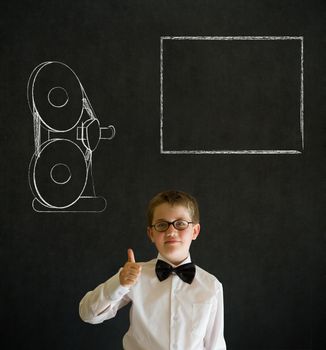 Thumbs up boy dressed up as business man with retro chalk film projector on blackboard background