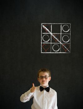 Thumbs up boy dressed up as business man with chalk tic tac toe love valentine concept on blackboard background