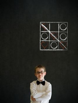 Thinking boy dressed up as business man with chalk tic tac toe love valentine concept on blackboard background