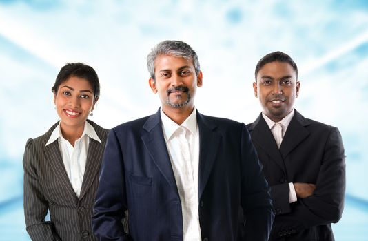 Indian business team.  Asian Indian businessmen and businesswoman in group. Teamwork concept standing inside office building. Good looking Indian model.