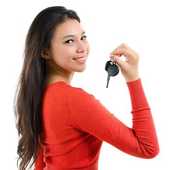 Attractive young woman holding her first own car key isolated on white background. Beautiful mixed race Caucasian Southeast Asian woman model.