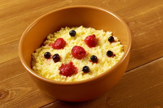 Millet porridge with berry in brown bowl on table