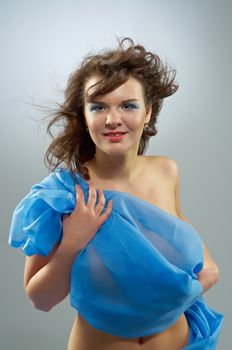 Beautiful woman in  waving fabric.Portrait of young dancing girl