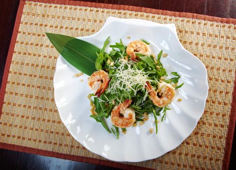 arugula salad with prawn on plate closeup