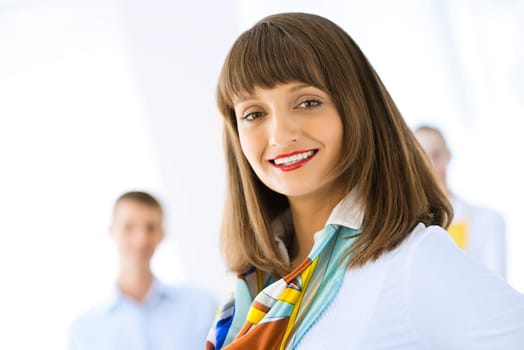 Portrait of a young successful business woman standing against colleagues