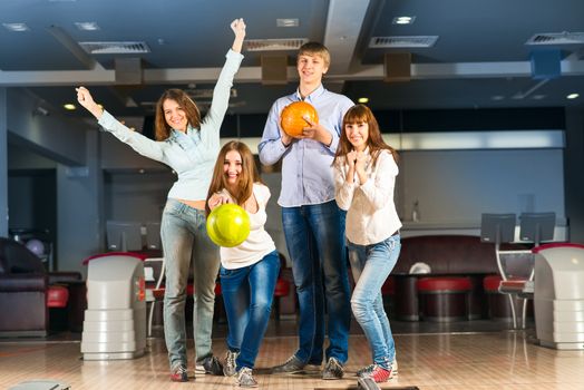 Group of young friends playing bowling, spending time with friends