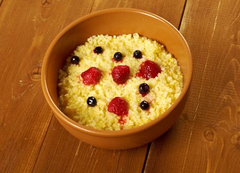 Millet porridge with berry in brown bowl on table