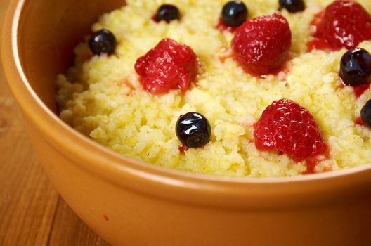 Millet porridge with berry in brown bowl on table