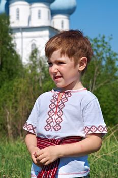 Russian little boy  on a orthodox church background.