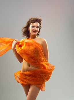 Beautiful woman in  waving fabric.Portrait of young dancing girl