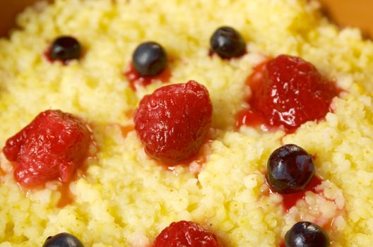 Millet porridge with berry in brown bowl on table